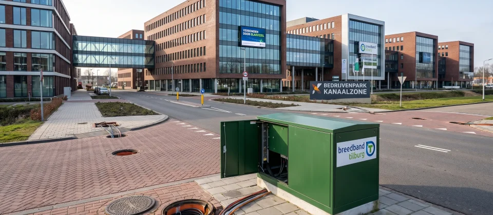 Een modern kantoorgebied in Tilburg met meerdere verbonden gebouwen en zichtbare glasvezelpuntjes bij de straat.